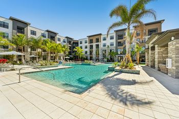 A swimming pool surrounded by palm trees and buildings.